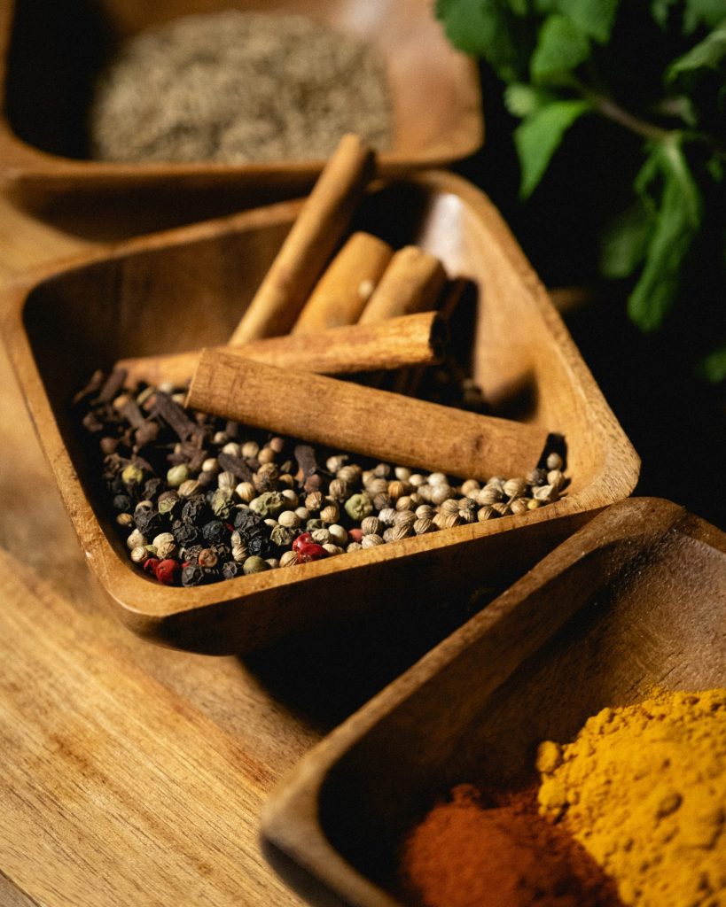 spices and herbs in wooden bowls on a table